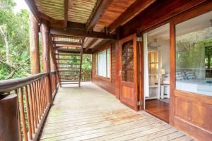 a wooden porch of a house with a glass door at Mar Azul 1B in Ponta Malongane