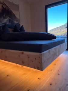 een slaapkamer met een groot bed en een groot raam bij Alpenlodges in Schönau am Königssee