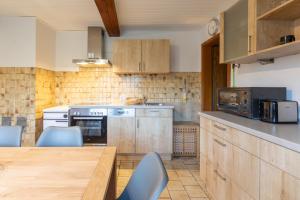 a kitchen with wooden cabinets and a wooden table at De Maade in Enge-Sande