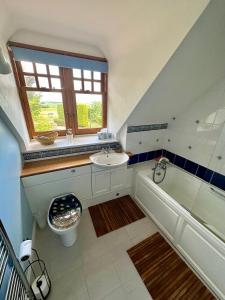 a bathroom with a sink and a tub and a toilet at Awakening Alchemy Retreat Centre in Inverurie