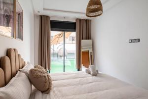een slaapkamer met een groot bed en een groot raam bij TT Holidays Cosy apartment Rabat City Center in Rabat