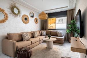 a living room with a couch and a table at TT Holidays Cosy apartment Rabat City Center in Rabat