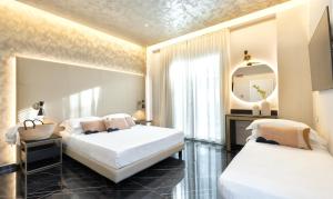 two beds in a room with a mirror at Hotel Mondial in Rimini