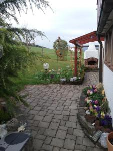 a patio with flowers and a gazebo at Haus Biggi - Ferienwohnung Hochgrat in Weiler-Simmerberg