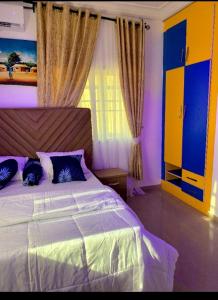 a bedroom with a large bed with blue pillows at Specfield Court And Apartment Sun City 