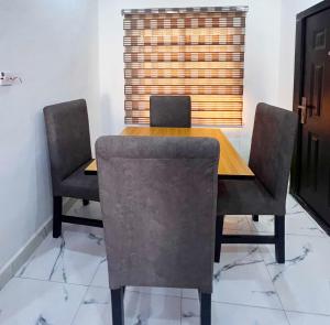 a dining room table with chairs and a window at Signature Residence in Calabar