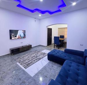 a living room with a couch and a tv at Signature Residence in Calabar