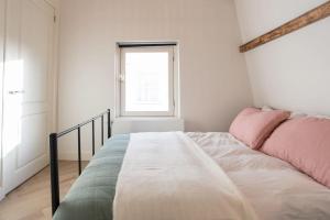 Schlafzimmer mit einem Bett mit rosa und grüner Bettwäsche in der Unterkunft Cozy B&B Prinsengracht in Amsterdam