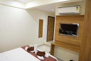 ein Hotelzimmer mit einem Bett und einem Flachbild-TV in der Unterkunft HOTEL PRESTON in Mumbai