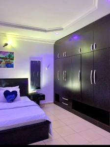 Schlafzimmer mit einem Bett und schwarzen Schränken in der Unterkunft Specfield Court And Apartment Sun City 