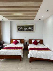a bedroom with two beds with red pillows at Thiên Thiên Thanh in Lao Cai