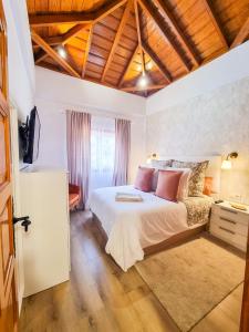 Schlafzimmer mit einem großen weißen Bett und Holzdecken in der Unterkunft Apartamento Sweet Aroma in Breña Baja
