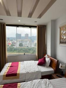 a hotel room with two beds and a window at Thiên Thiên Thanh in Lao Cai