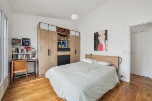 a bedroom with a large bed and a desk at Duplex familial à necker by Weekome in Paris