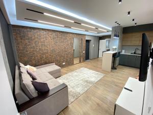 a living room with a couch and a brick wall at RentNow Large and Cozy Apartment in the Center, Parking in Chişinău