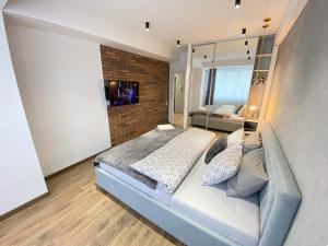 sypialnia z dużym łóżkiem i ceglaną ścianą w obiekcie Large and Cozy Apartment in the Center w Kiszyniowie