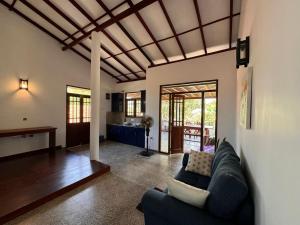 希卡杜瓦的住宿－Serenique Heaven，一间带蓝色沙发的客厅和一间厨房