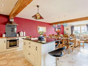 a kitchen with red walls and a dining room at 3 Bed in Conwy 74146 in Eglwys-Fâch