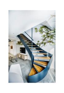 escalera de caracol en una sala de estar con sofá blanco en Riam suites apartamentos, en Los Palacios y Villafranca