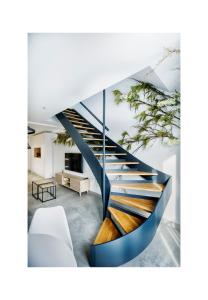 a spiral staircase in a living room with a white couch at Riam suites apartamentos in Los Palacios y Villafranca