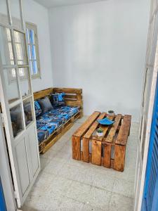 Habitación con cama y mesa de madera. en App 2 chambres piscine privative 600m plage en Mezraya
