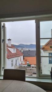 una camera da letto con una grande finestra che si affaccia sugli edifici di Mulen: Lokal sjarm, naturopplevelser i Bergen a Bergen
