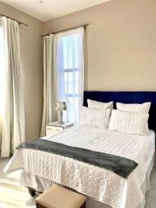 1 dormitorio con 1 cama grande y cabecero azul en Kandembas nook en Lusaka