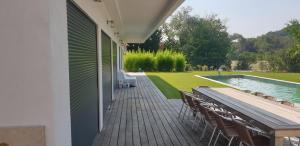 een terras met een tafel en stoelen naast een zwembad bij La lavandière in Fox-Amphoux