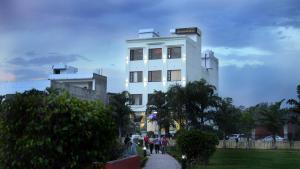 a white building with people walking in front of it at Hotel Park Street in Pathānkot