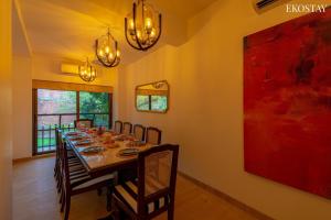een eetkamer met een lange tafel en stoelen bij EKOSTAY Luxe - Casa Marina in Candolim