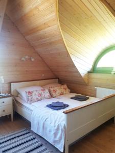 uma cama num quarto com tecto em madeira em Siedlisko pod Aniołem em Grabówko