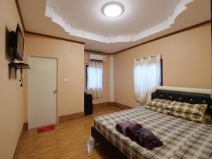 a bedroom with a bed with a checkered blanket at Boonsong Guest House in Khao Tao