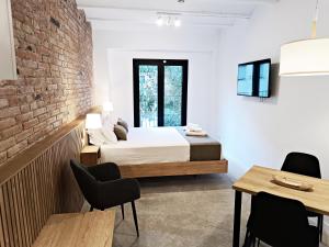 略夫雷加特河畔奥斯皮塔莱特ARIQUS Fira Apartments的一间带床和砖墙的卧室