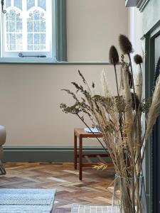 a vase filled with dried flowers next to a table at Cathedral View Apartment, Flat 4 in Bury Saint Edmunds