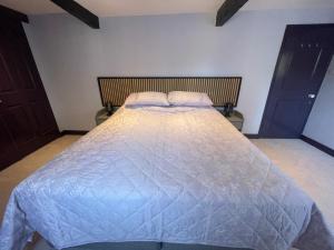a bedroom with a bed with a blue comforter at Cathedral View Apartment, Flat 4 in Bury Saint Edmunds
