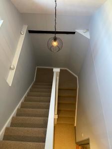 eine Treppe mit einem Kronleuchter und einer Treppe in der Unterkunft Cathedral View Apartment, Flat 4 in Bury Saint Edmunds