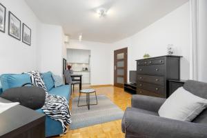 a living room with a blue couch and a kitchen at Bukowińska Apartments with Balcony and Parking and Swimming Pool by Renters in Warsaw