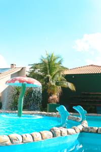 een zwembad met een fontein en een parasol bij Family Eco Thermas in Olímpia