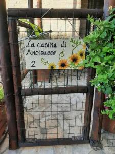 a sign on a fence with sunflowers on it at La Casina di Ancicucco 2 in San Gimignano