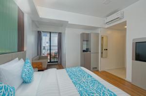 1 dormitorio con 1 cama grande y TV en Arena Beach Hotel, en Maafushi