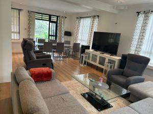 sala de estar con sofá y TV de pantalla plana en Cinnamon House, en Kisumu