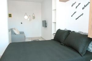 een slaapkamer met een groen bed en een bank bij Family Eco Thermas in Olímpia