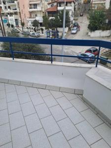uma varanda com um corrimão azul e um parque de estacionamento em Spitaki em Kavala