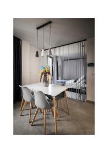 comedor con mesa blanca y sillas en Riam suites apartamentos, en Los Palacios y Villafranca