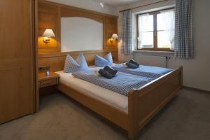 ein Schlafzimmer mit einem Bett mit blauen Laken und einem Fenster in der Unterkunft Landhaus Exclusiv in Bolsterlang + 46 Fotos