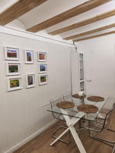 a dining room with a glass table and chairs at EL RINCÓN deMANUELA in Requena