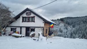 a building with snow on the ground in front of it at Casa Bună Fundățica in Fundăţica