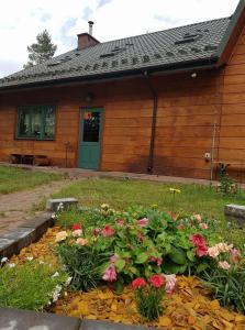 uma casa com um jardim de flores em frente em Leśna Odnowa em Borków