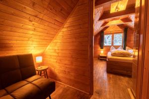a room with a bed and a couch in a cabin at Almhütte Hebalm mit Whirpool in Pack