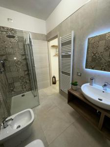 een badkamer met een wastafel, een douche en een toilet bij Perla Saracena in Lucera